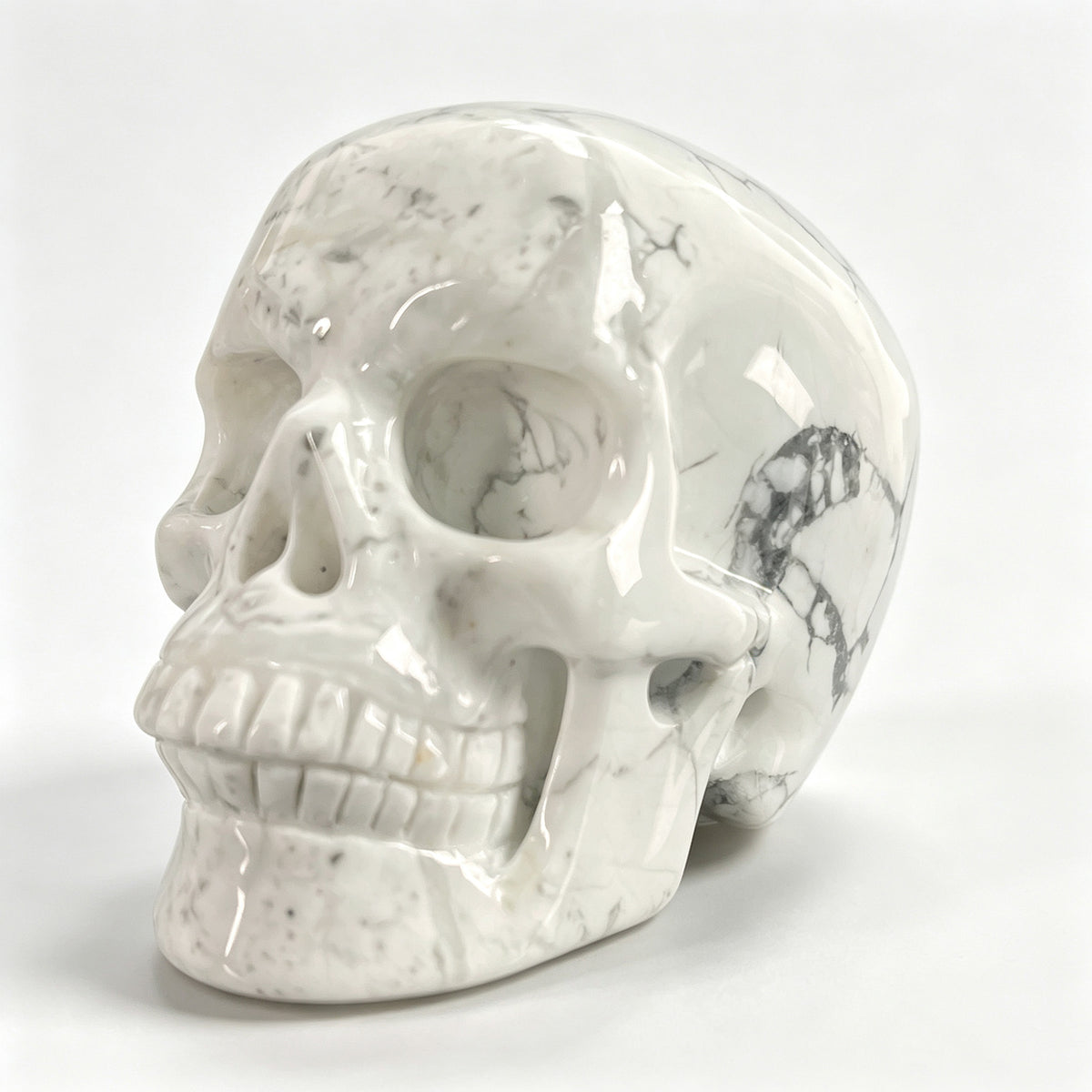 Left-front view of a 3-inch White Howlite human skull carving