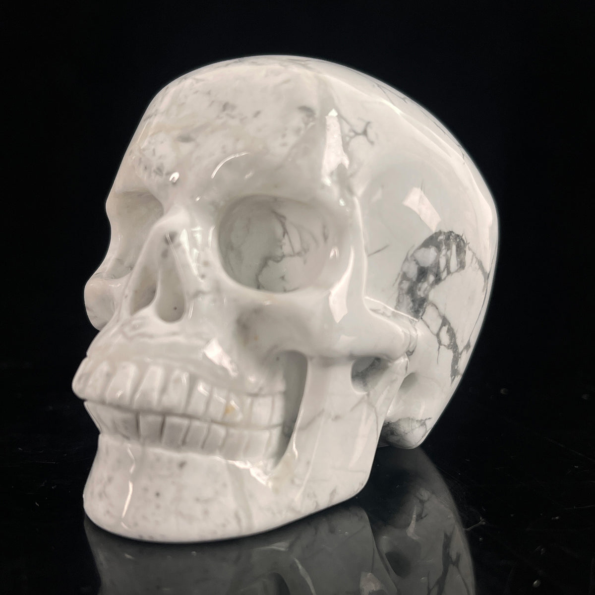 Left-front view of a 3-inch White Howlite human skull carving