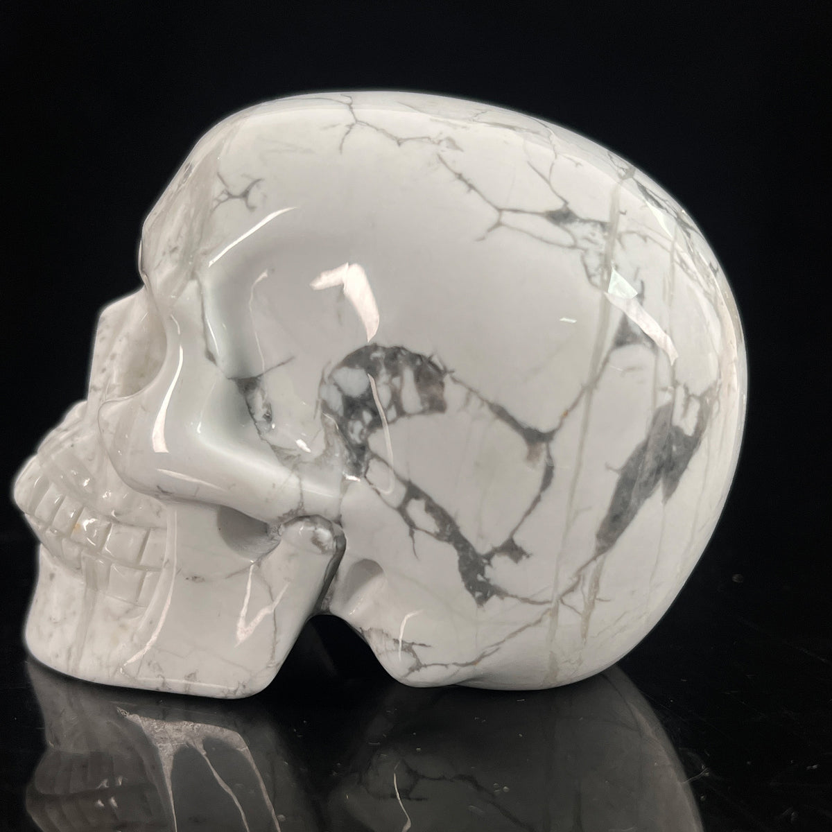 Left-side view of a 3-inch White Howlite human skull carving