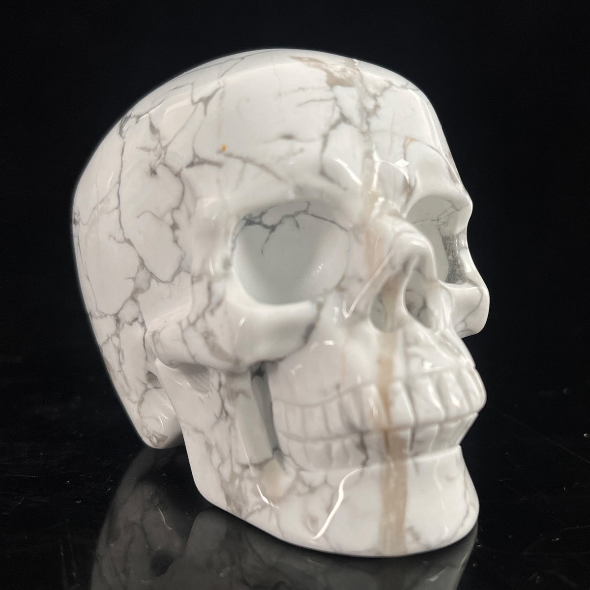 Right-front view of a 3-inch White Howlite human skull carving