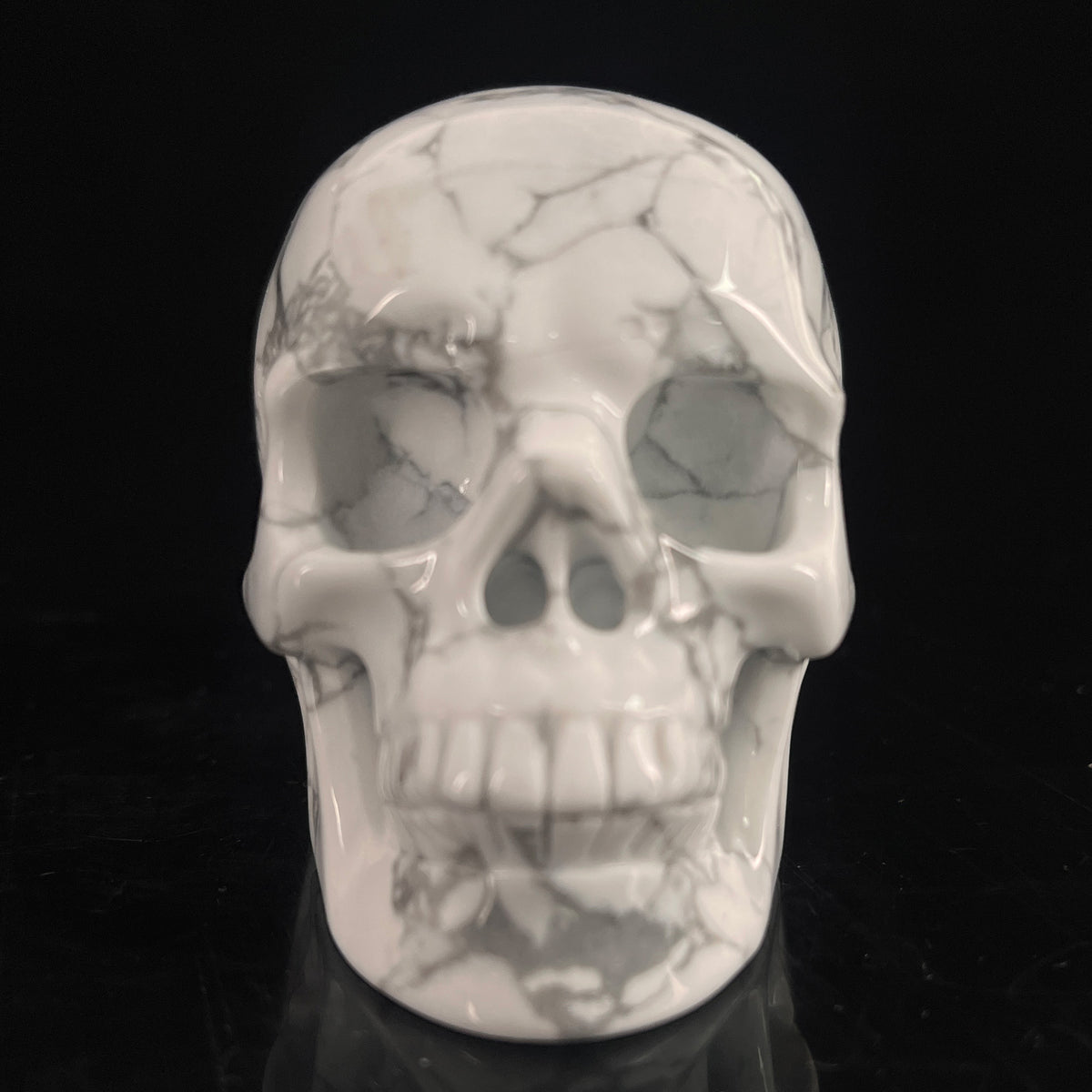 Front view of a 3-inch White human skull carving