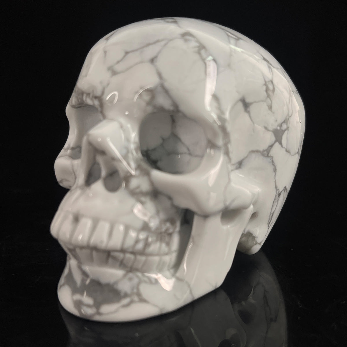 Left-front view of a 3-inch White human skull carving