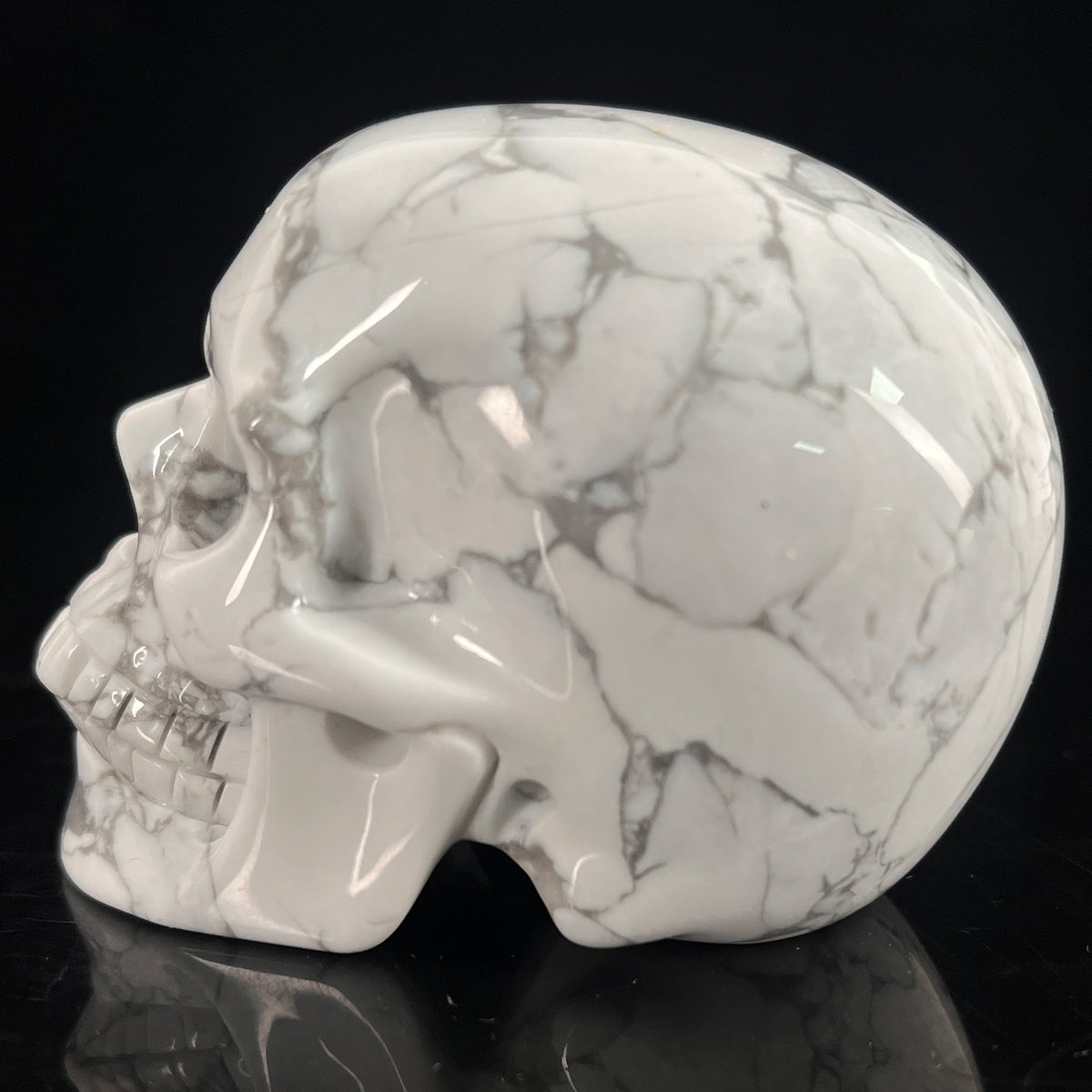 Left view of a 3-inch White human skull carving