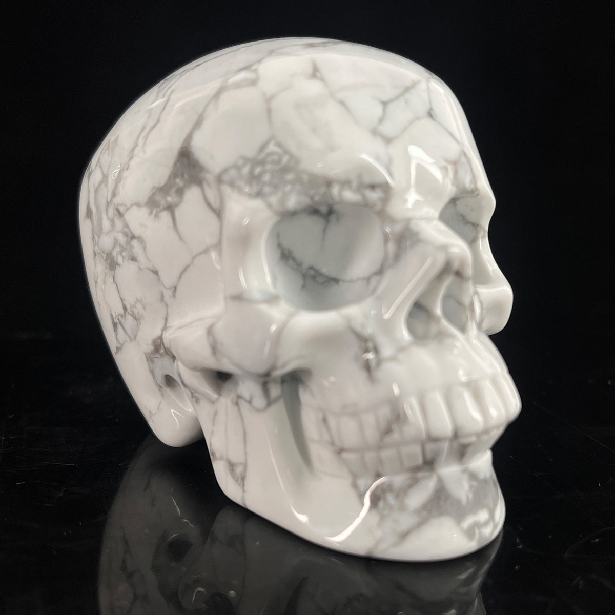 Right-front view of a 3-inch White human skull carving